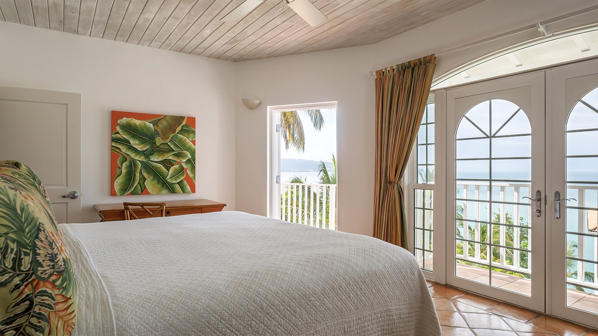 hotel guestroom with doors on to terrace with palm motif designs