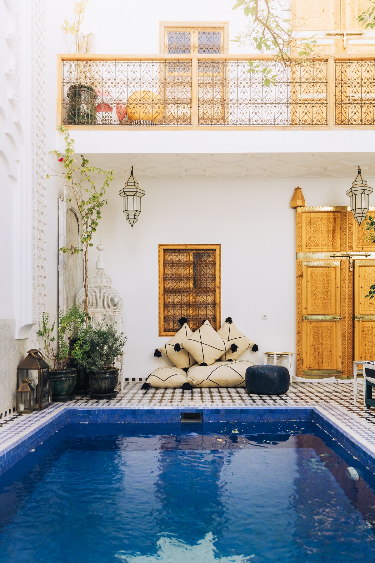 tiled swimming pool in riad courtyard with cushions and plants