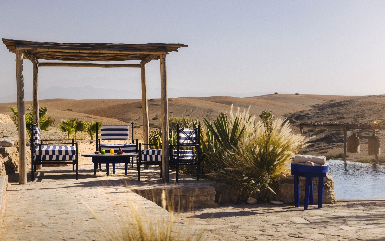 outdoor seating at Habitas Caravan Agafay overlooking pool