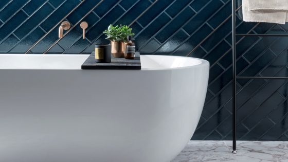 white freestanding bath with blue tiles from Parkside behind and a ladder towel rail alongside