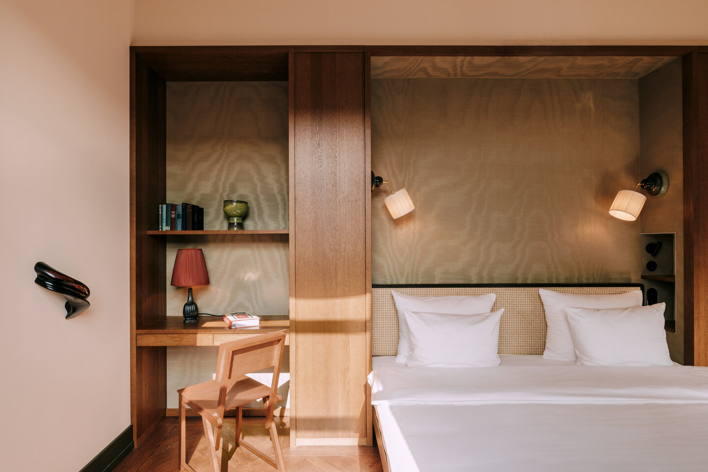 bed in guestroom at Chateau Royal berlin set in wooden back wall with shelf and light detail