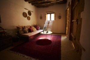 room in hotel in AlUla with sun shining through window onto mud surfaces