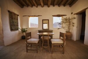 table and chairs in front of a window in hotel in AlUla