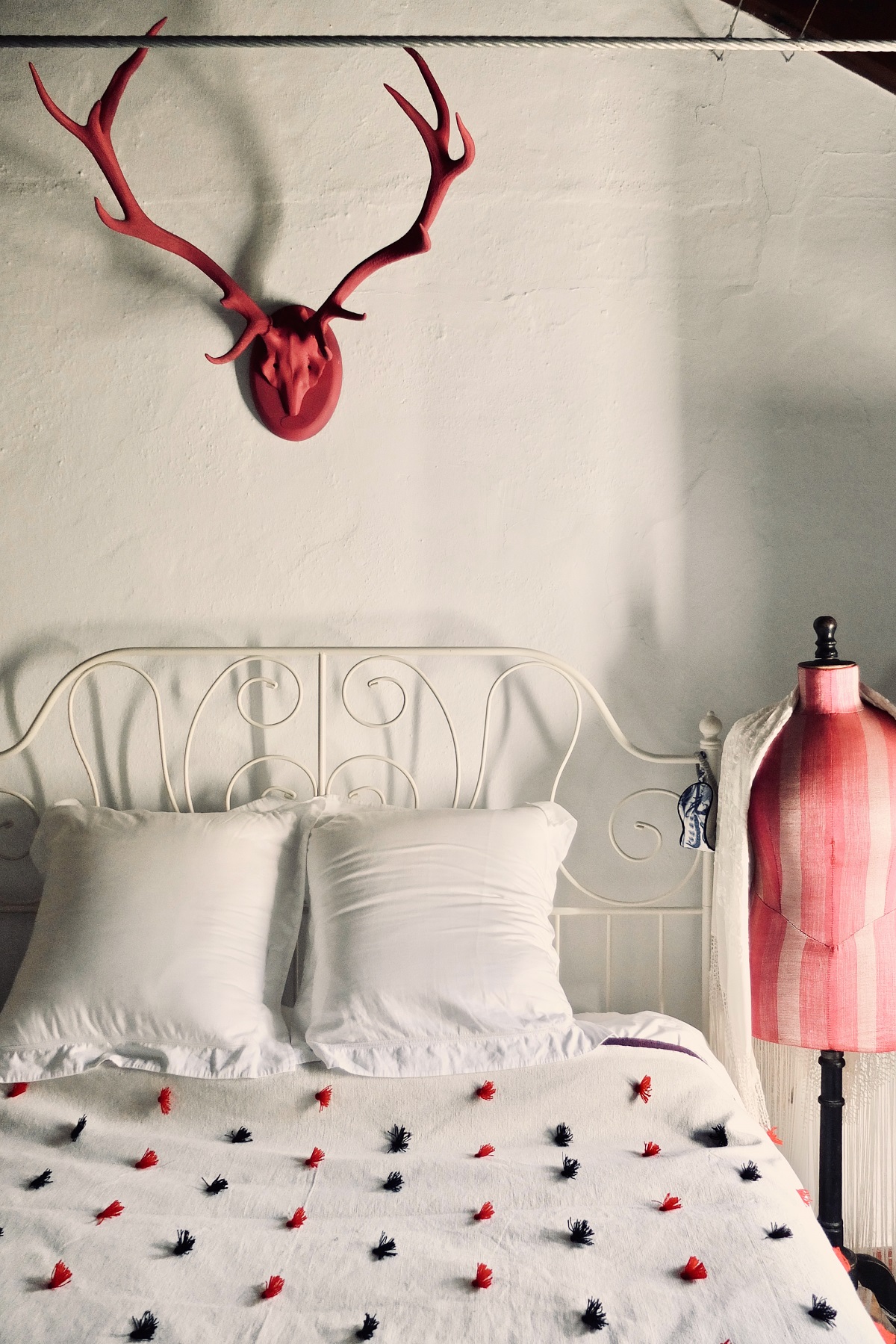 vintage bed detail with handwoven throw in boutique hotel Finca La gloria