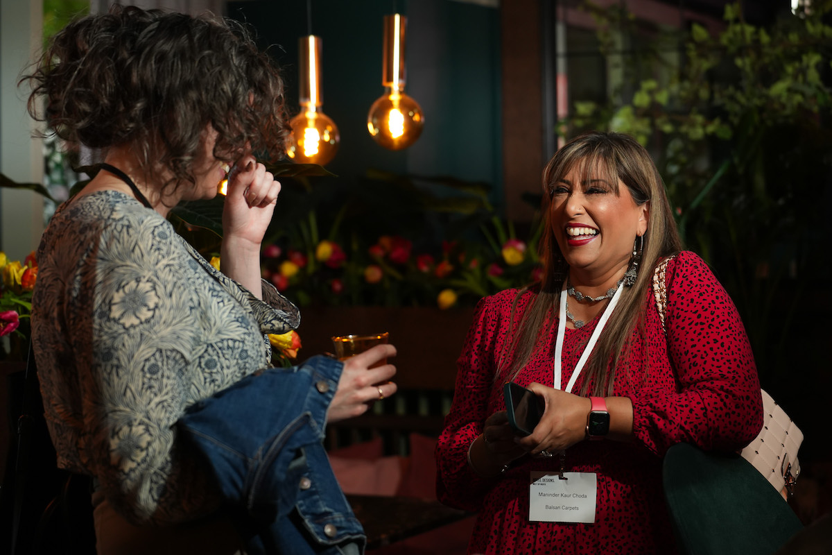 A woman in red dress laughing at MEET UP North 2023