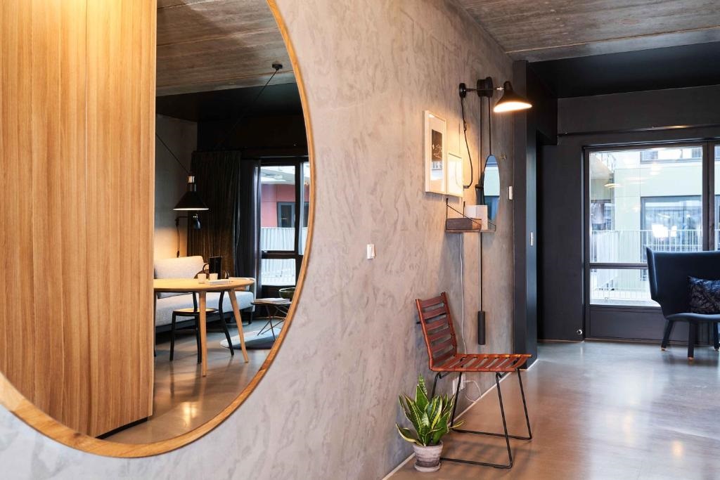 circular mirror with light wood frame reflecting hotel guestroom