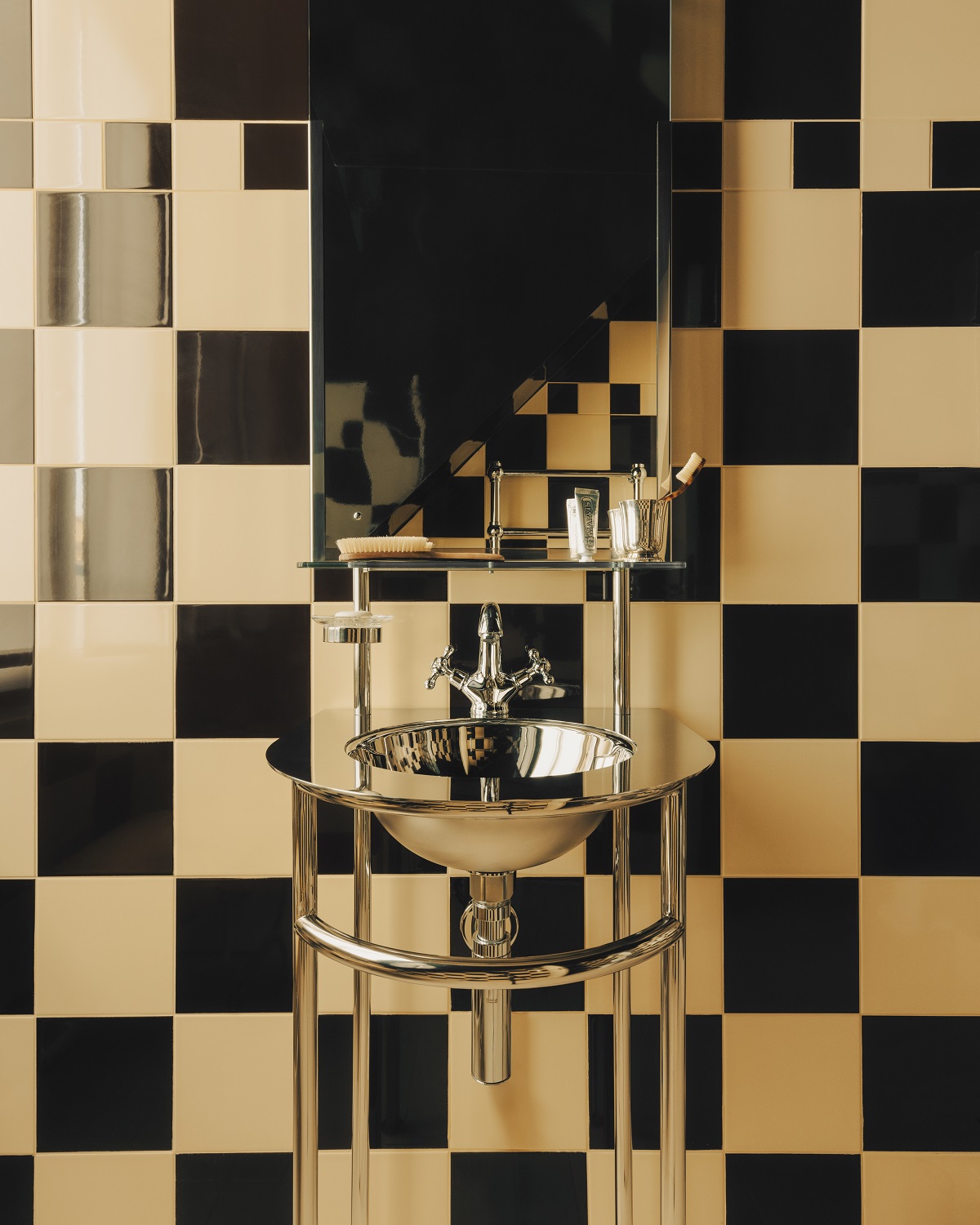 black and white chequerboard tiled bathroom with chrome fittings