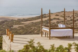 moroccan day bed on terrace looking out across dunes to the sea