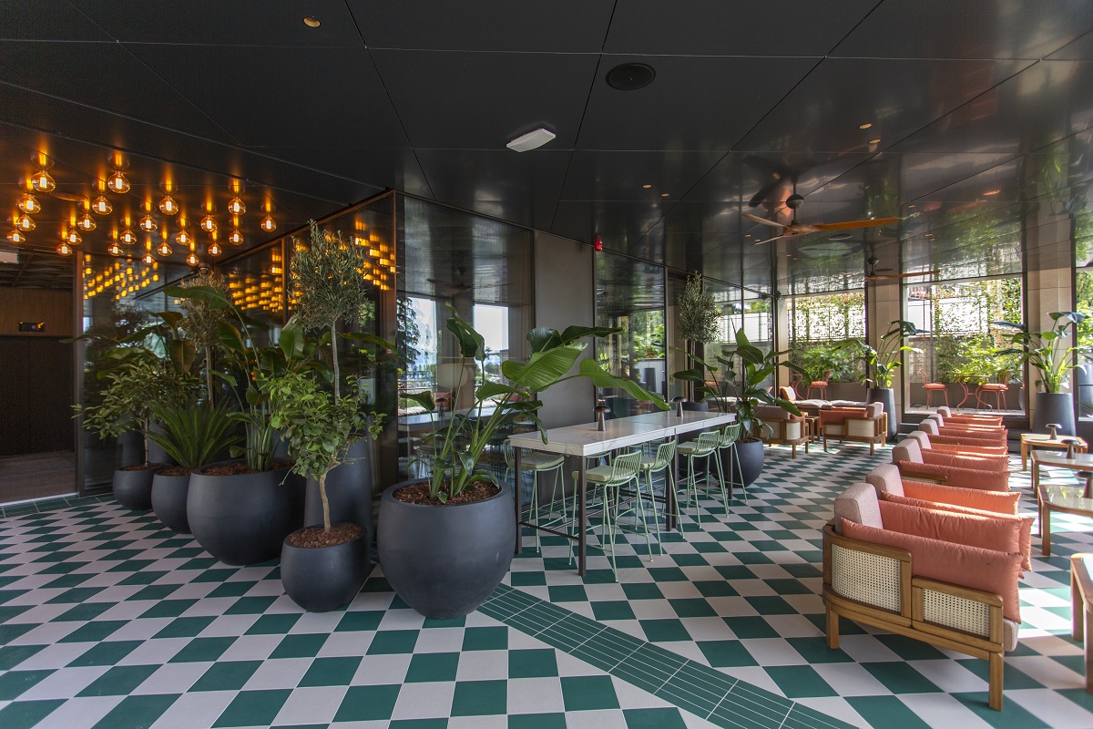 hotel lobby with green tiled floor, plants and seating