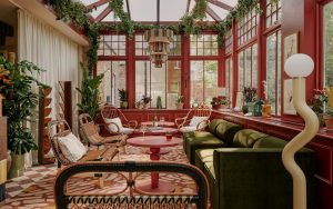 seating area in ember Locke in shades of terracotta and green with plants and wicker furniture