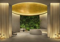 gold vaulted ceiling in the cream lobby with planted wall in The Singapore EDITION