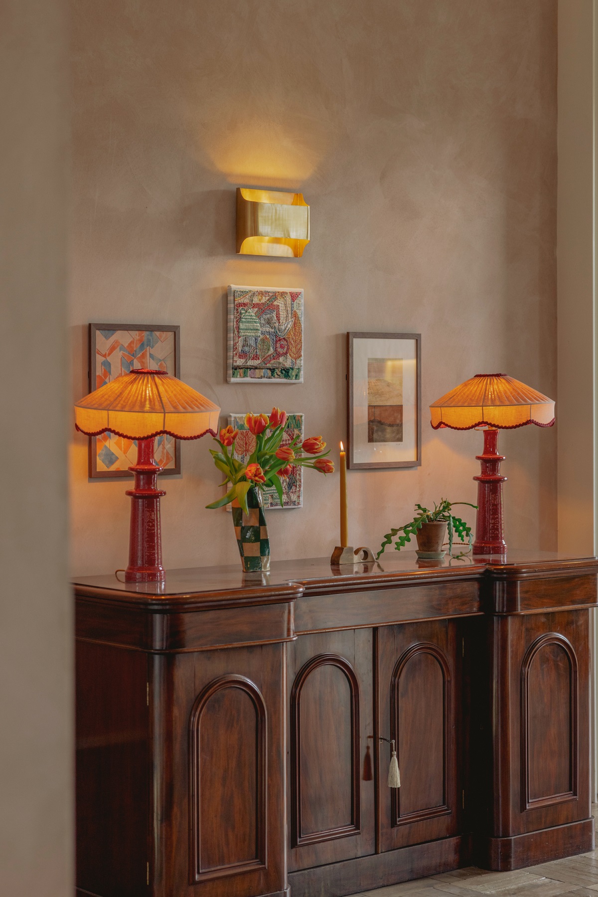 gallery wall with period lighting and a wooden cabinet