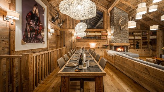 Modern alpine interiors inside Chalet Inoka, with large contemoporary artwork on wall and cloud-like chandeliers from ceiling