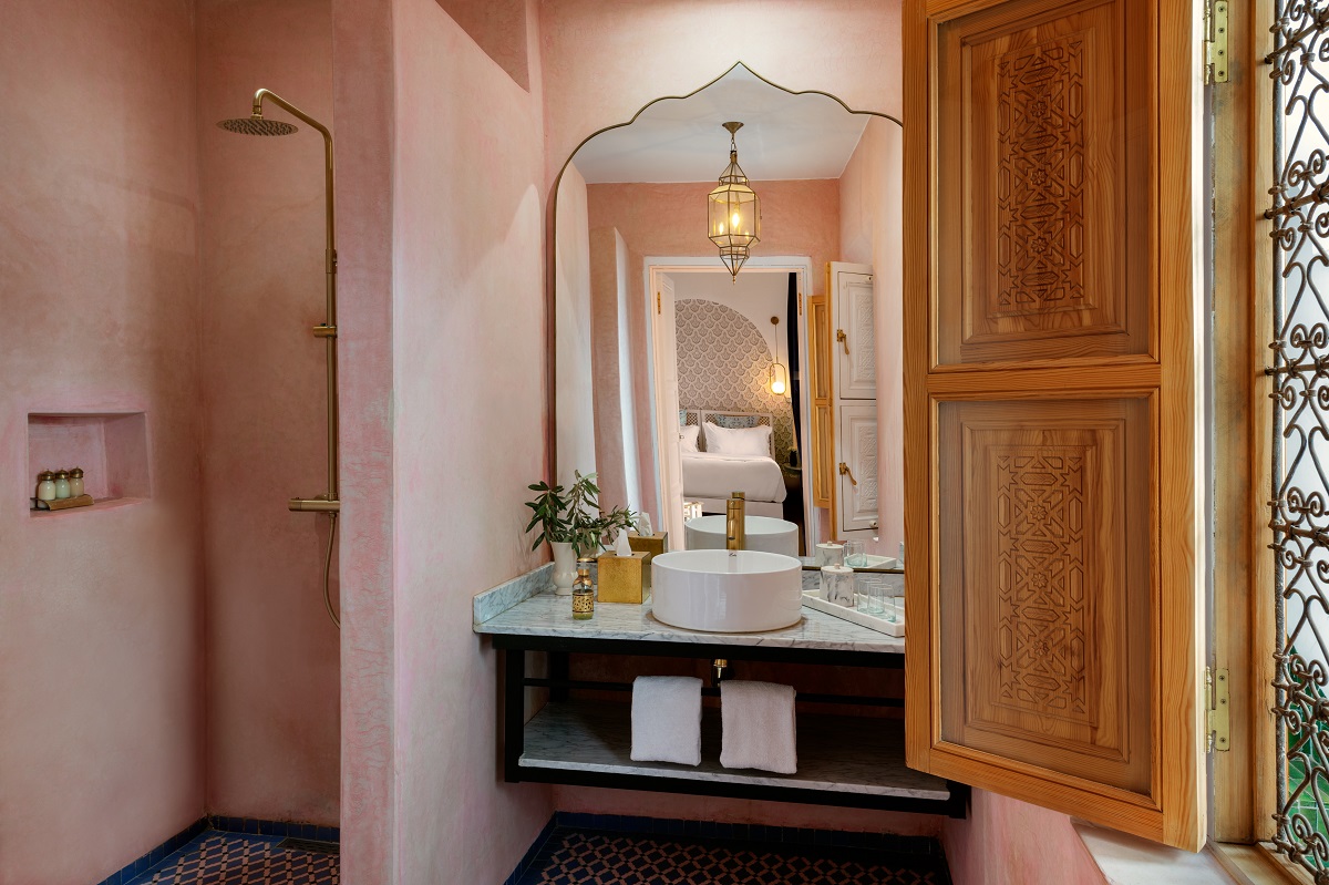 pink plaster ensuite bathroom with mirror reflection into the bedroom