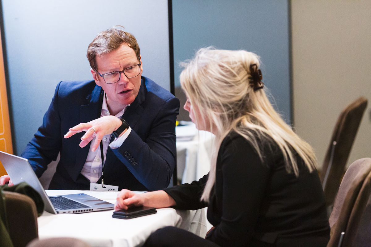 A man and woman in a meeting at a Forum Events Summit