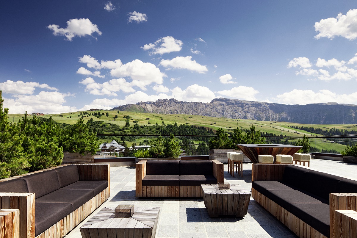 wooden deck and furniture on outdoor terrace at COMO Alpina Dolomites