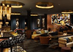 dark, moody bar in rosewood Munich with focus lighting and statement mural on the wall