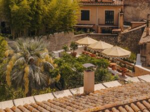 view across hotel rooftop and Girona overlooking pool terrace and umbrellas