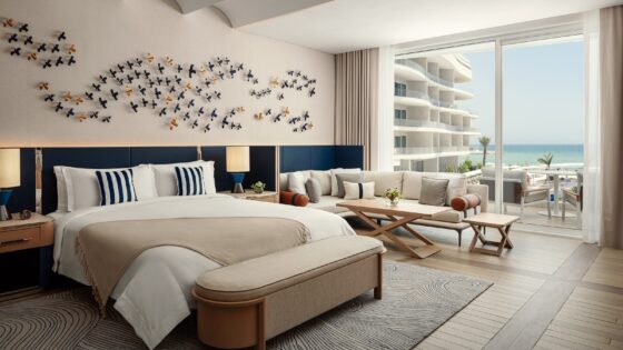 sand coloured throw and blue headboard in guestroom at The St. Regis Al Mouj Muscat Resort