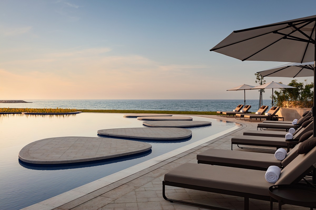 sunloungers around pool with ocean view