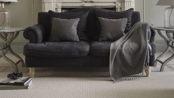 brown couch on natural wool carpet in front of period fireplace