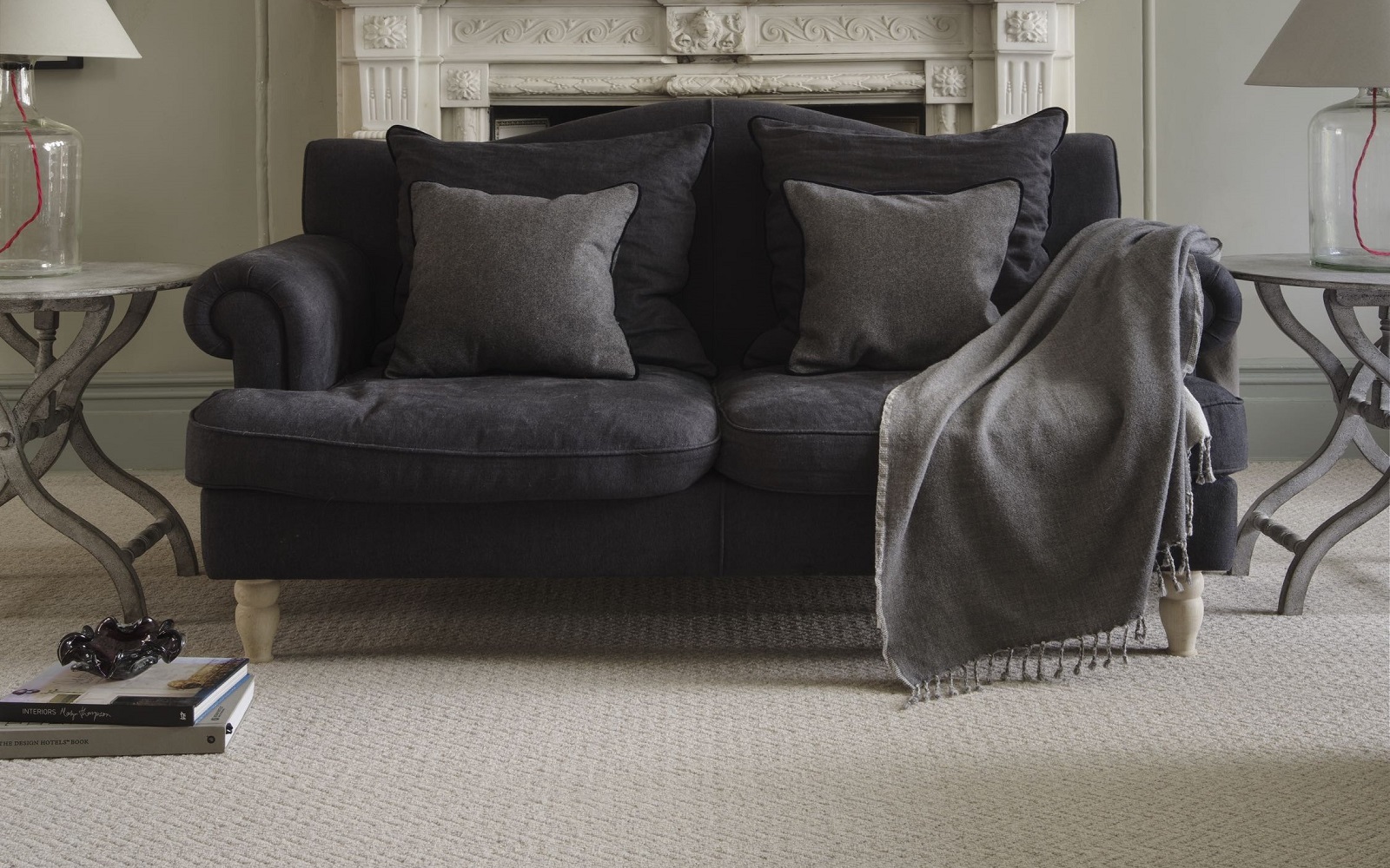 brown couch on natural wool carpet in front of period fireplace